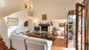 Un salon avec un canapé, une table basse, une cheminée et un téléviseur.