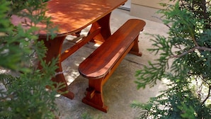 A wooden picnic table with benches in front of a beige building with a door labeled "Laci 2". - Holiday apartment with large garden and internet (Balatonföldvár)