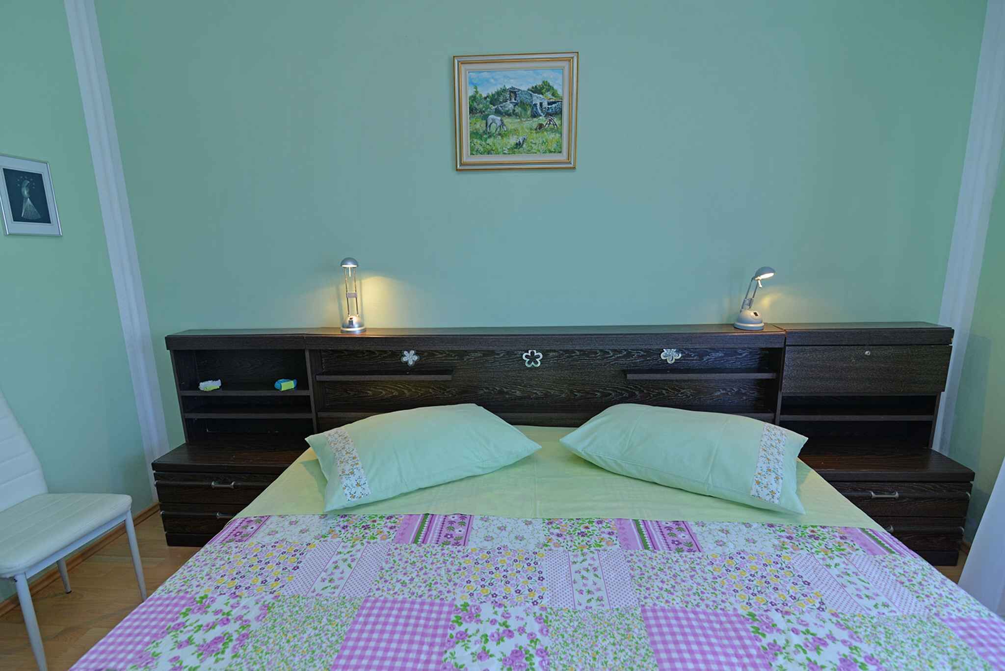 Une chambre à coucher avec un lit, deux lampes de chevet, une commode et un tableau encadré au mur.
