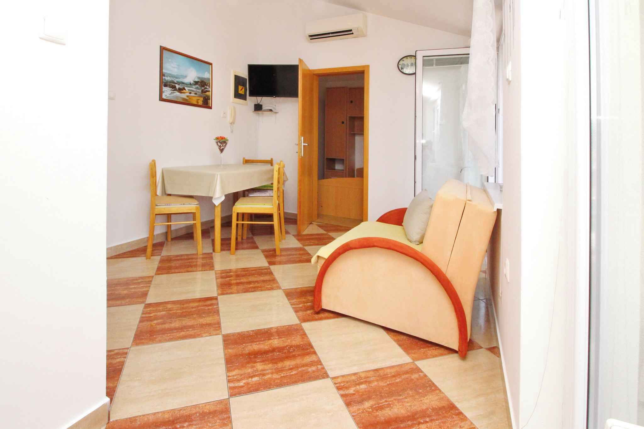 A compact living space with a dining area, a sofa, and a television.