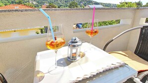 Une table avec deux verres contenant une boisson jaune, une petite lanterne et une chaise.