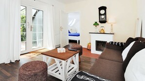Ein Wohnzimmer mit einer Couch, einem Tisch und einem Kamin.
