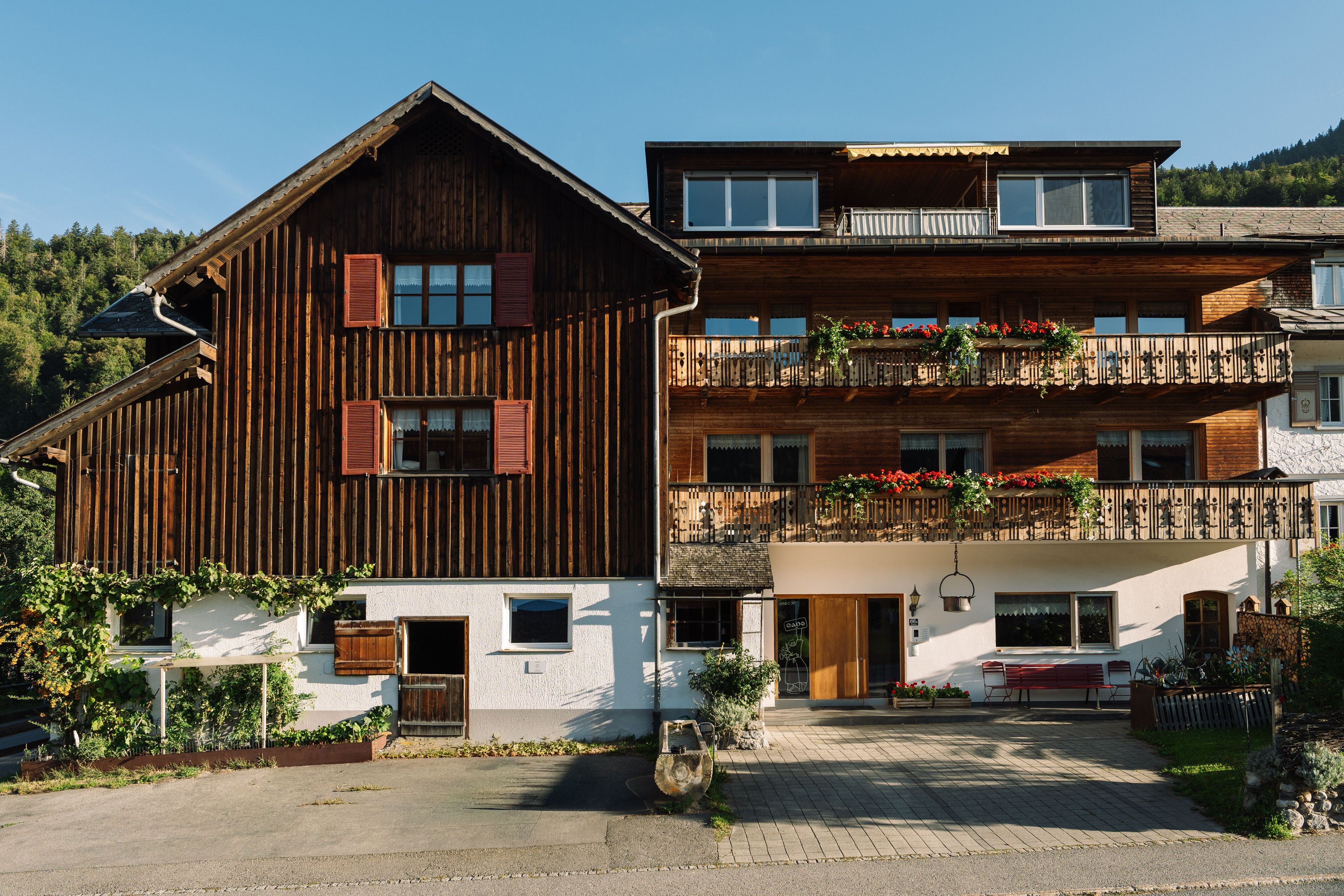 Ein zweistöckiges Holzhaus mit Balkon und Blumenkästen.