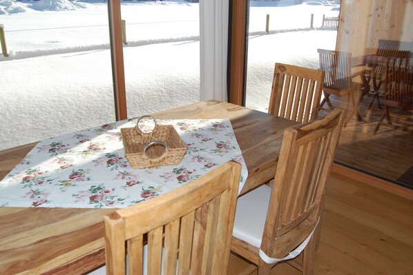 Una mesa de madera con mantel floral y una cesta.
