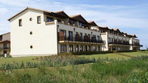 A multi-story hotel with a consistent architectural style, featuring balconies and a flat roof.
