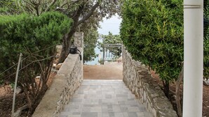 Eine Steintreppe führt zu einem Tor mit Blick auf das Meer.