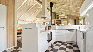 A modern kitchen with white cabinetry, a black and white checkered floor, and a wooden ceiling. - 3 bedroom beautiful home in Hjørring (Hjørring)