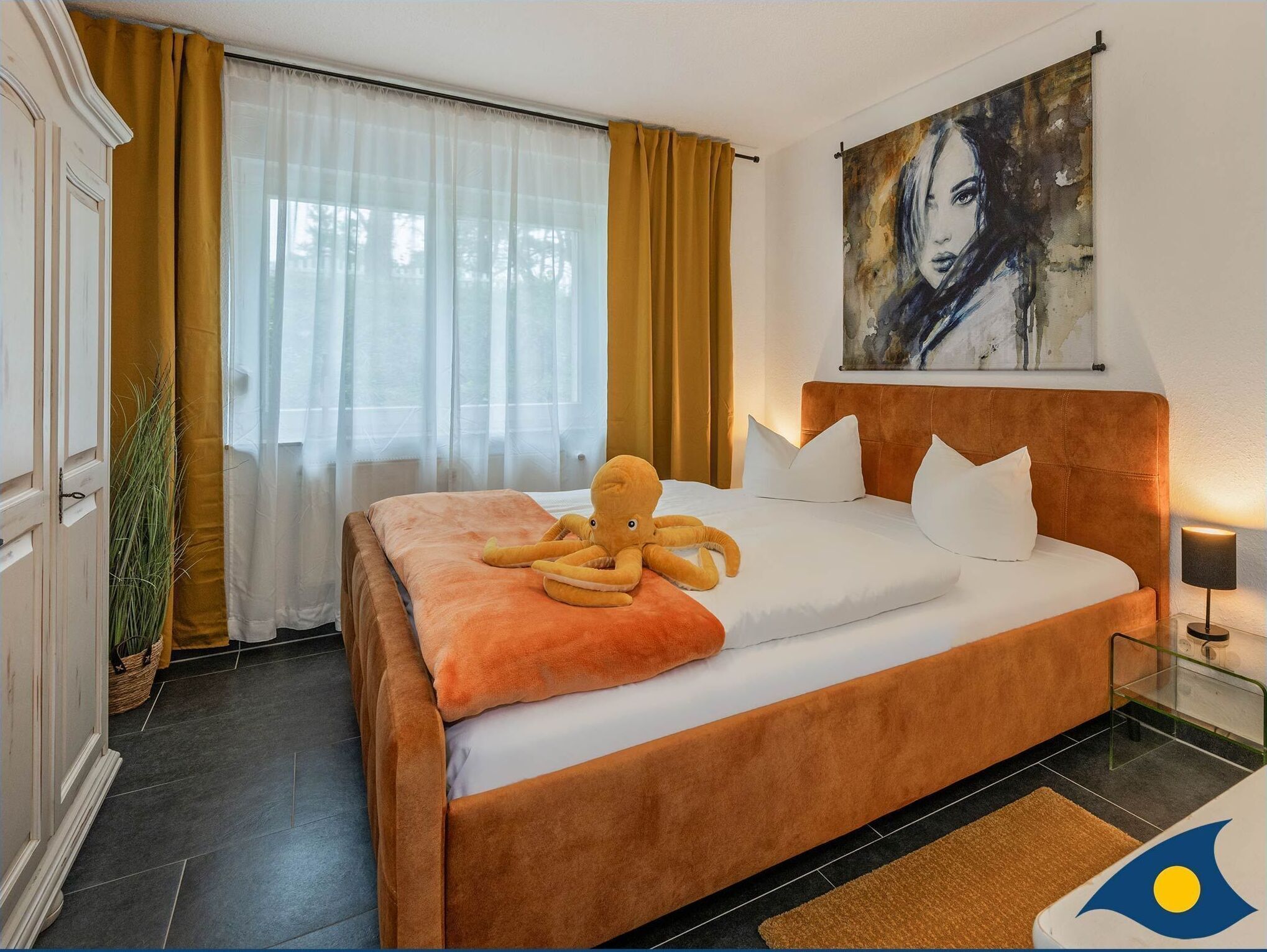Une chambre d’hôtel avec un grand lit, un tableau au mur et une fenêtre avec des rideaux.