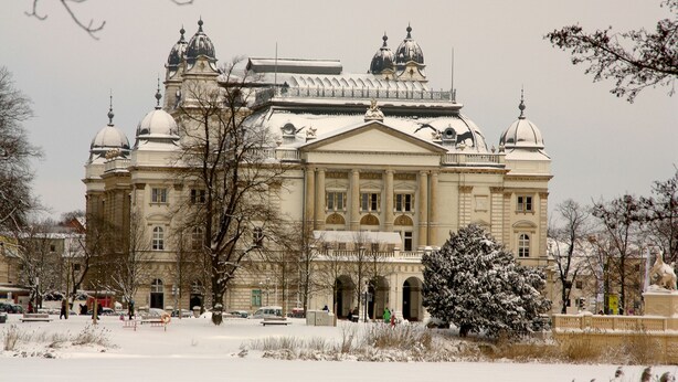 A large, historic building with multiple domes and a central entrance.