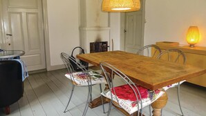 A dining area with a wooden table and metal chairs, a wicker pendant light, and a small table with a lamp. - 2 bedroom amazing home in Markaryd (Markaryd)