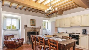 Eine geräumige Küche mit Kochinsel, Holzschränken und Kamin.
