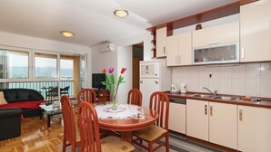 Un ambiente compatto con angolo ristoro, cucina e balcone con vista.