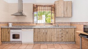 Una cocina con armarios de madera, horno empotrado y lavavajillas.