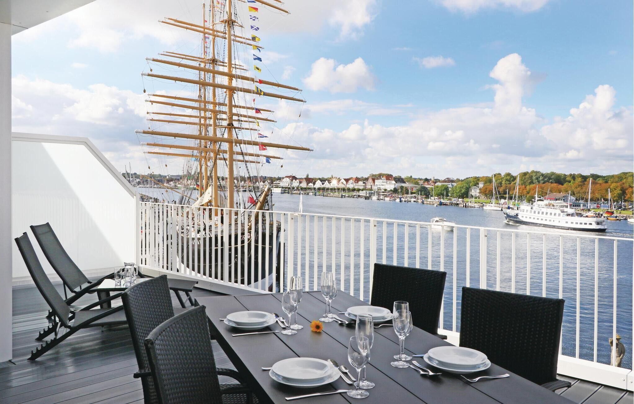 Ein Essbereich mit Blick auf einen Hafen, inklusive eines Segelschiffs und Booten.