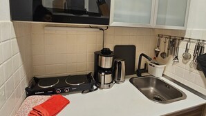 Une cuisine équipée d’un four encastré, d’une machine à café, d’un évier et d’un porte-ustensiles.