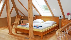 Ein Schlafzimmer im Loft-Stil mit einem Holzbett, einem Oberlicht und Holzboden.