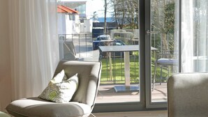 A modern living room with a large sliding glass door leading to an outdoor patio area.