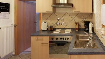A compact kitchen with a stove, sink, and a small countertop area.