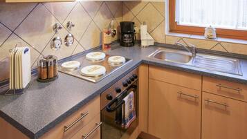 A modern kitchen with a granite countertop, stainless steel appliances, and wooden cabinets.