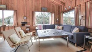 Hyggelig hytteindretning med sofa, stol, sofabord og radio.