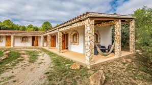 A stone building with a covered patio area and a hammock.