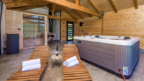 Sauna, jossa on puiset penkit, poreallas ja näkymä ulos.