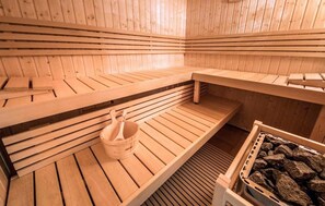 A sauna with wooden benches and a stone basin. - Ferienhaus 32 in Kirchheim (Kirchheim)