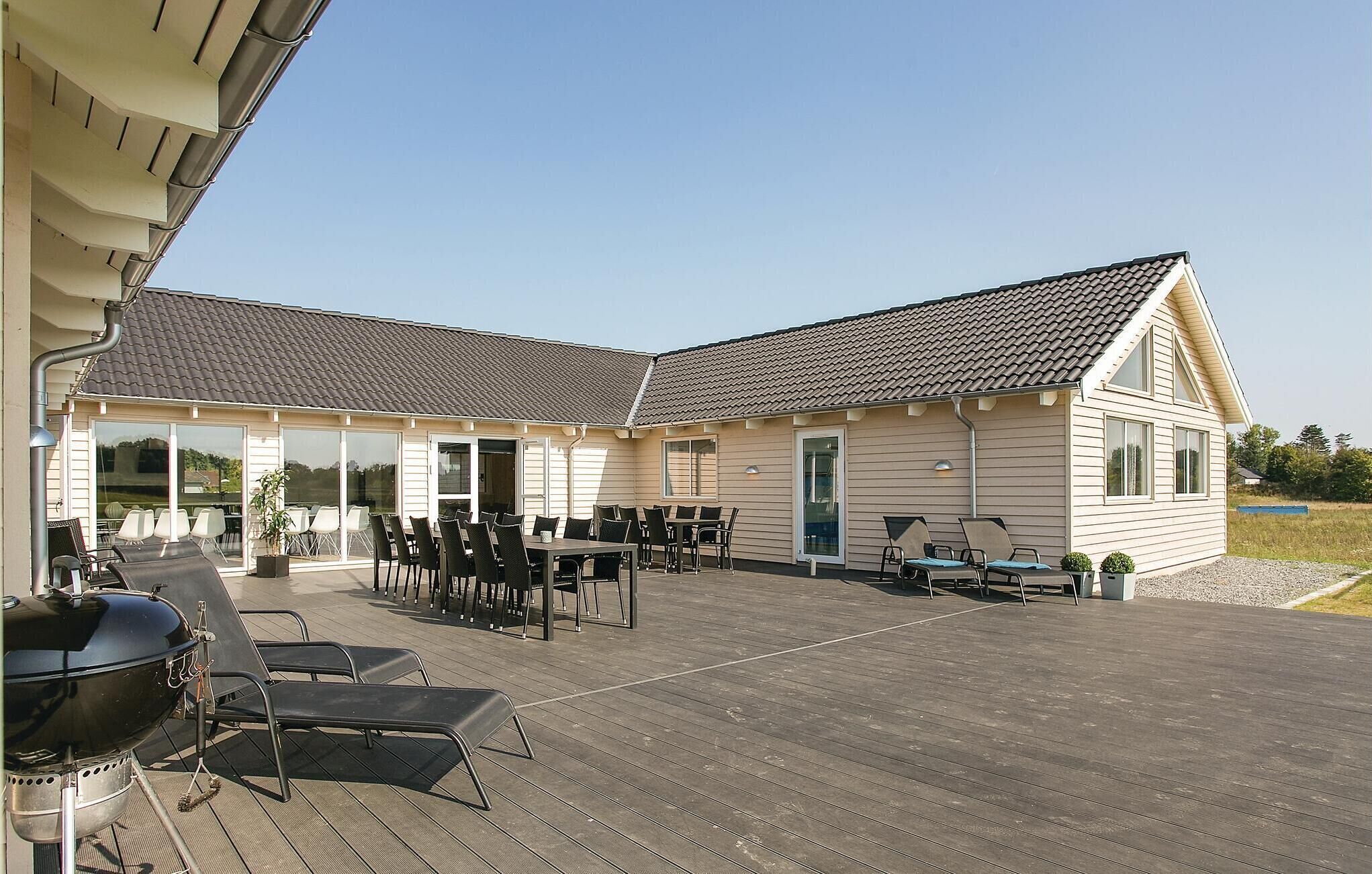 Un bâtiment doté d’un patio couvert, d’un espace extérieur aménagé pour s’asseoir et d’un barbecue.