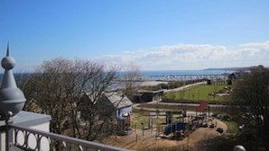 Une vue sur la côte, avec un ciel dégagé, une aire de jeux et une ligne de rivage lointaine.