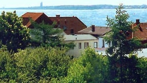 Um imóvel costeiro com várias construções, vegetação densa e vista para o mar.