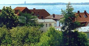A coastal property with multiple buildings, dense greenery, and a view of the sea.