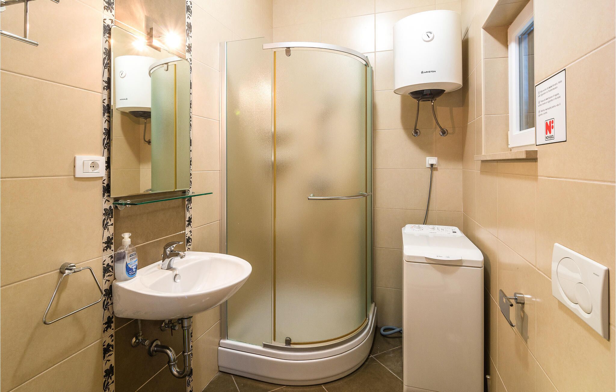 Une salle de bain moderne avec une douche à parois de verre, un lavabo blanc et des toilettes compactes.