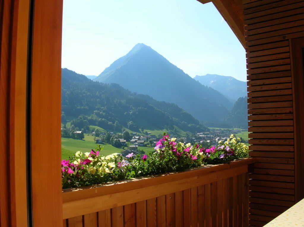 A wooden balcony with a view of a mountain landscape.