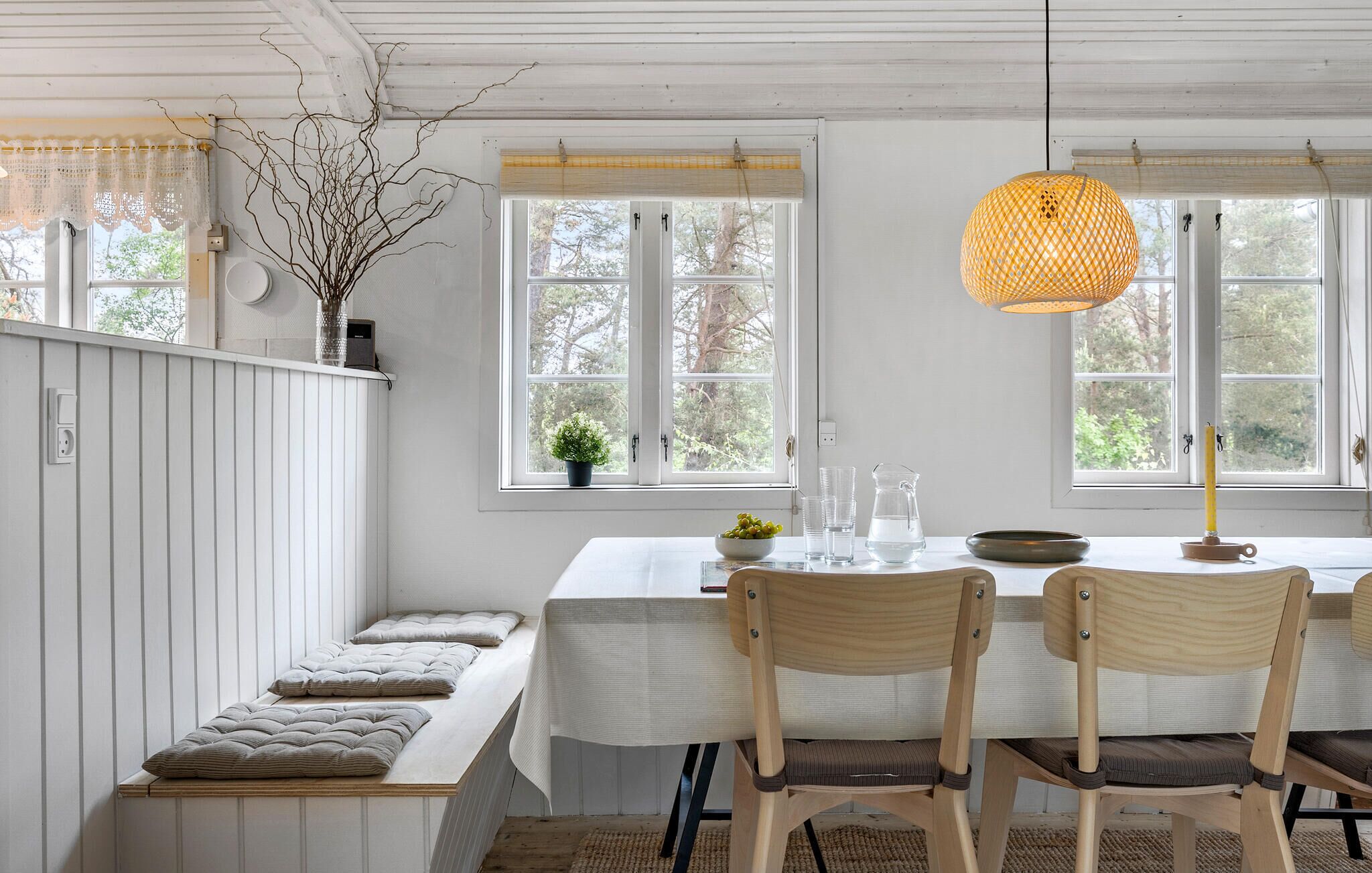 Un espace repas comprenant une banquette, une table et deux chaises.