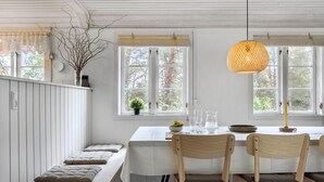 Un área de comedor con un banco, una mesa y dos sillas.
