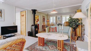 Una sala de estar acogedora con chimenea, televisión y comedor.