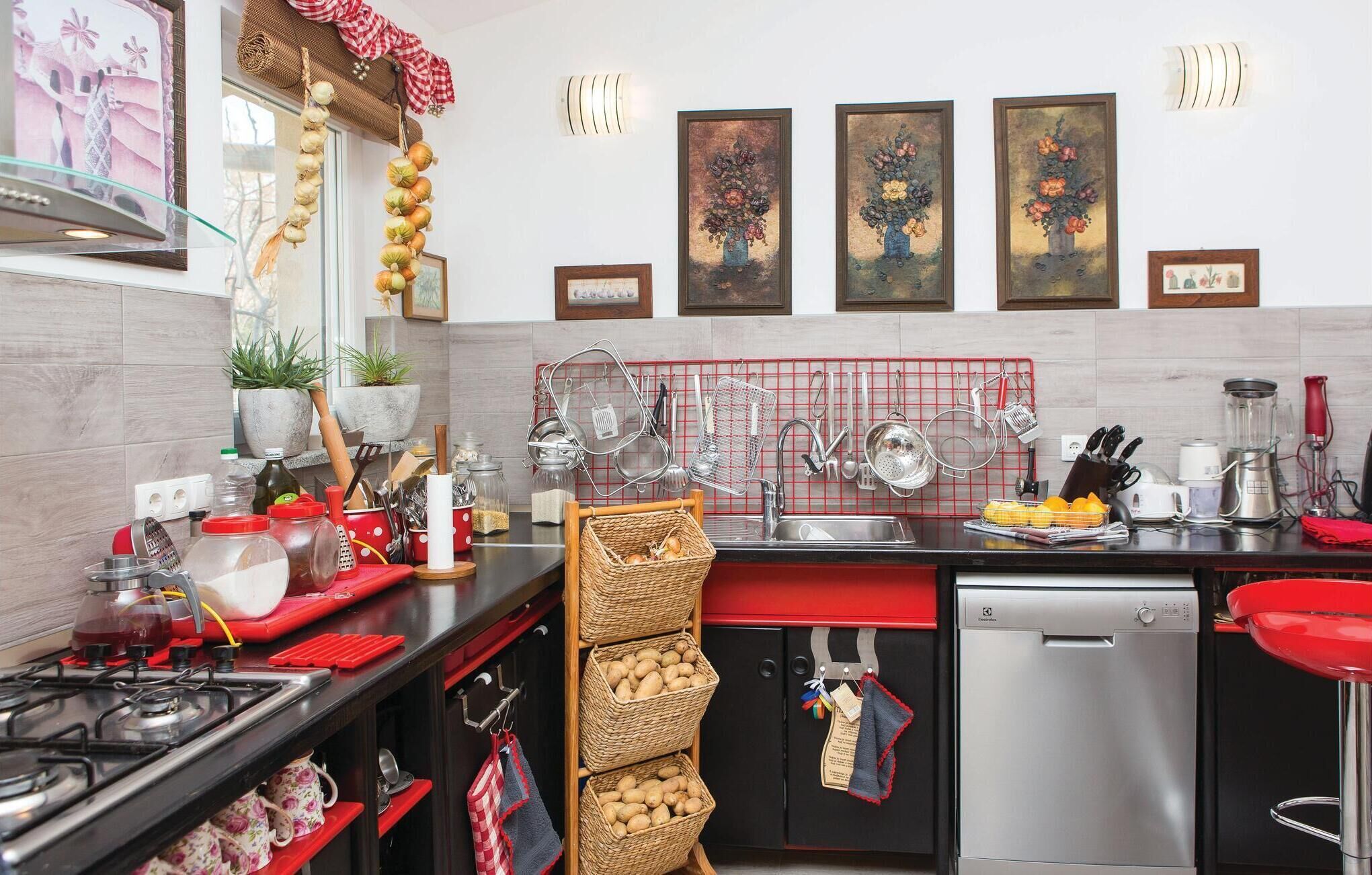A modern kitchen with a gas stove, stainless steel appliances, and a red and black color scheme.