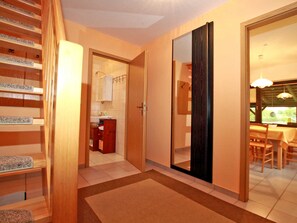 A modern interior with a wooden staircase, a kitchen area, and a dining space with a view. - Holiday house on Klostergrund - holiday home (Malchow)