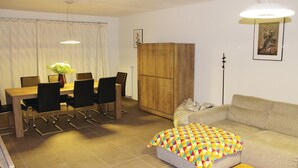 Ein Wohnzimmer mit einer Couch, einem Couchtisch und einem Essbereich mit Tisch und Stühlen.