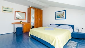 Un dormitorio con cama, escritorio, armario y espejo.