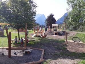 A playground with swings, climbing structures, and a sandbox.