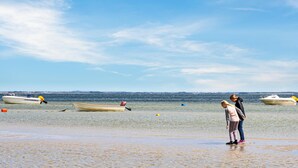 Una playa con barcos y gente.