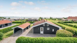 Zona residencial con casas, un porche cubierto y vistas al mar.