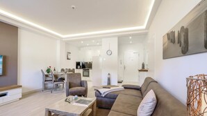 Una sala de estar moderna con un sofá, una mesa de centro y una zona de comedor.