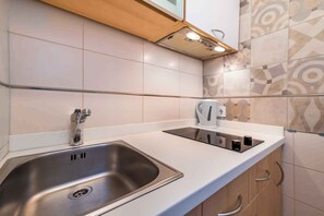 A modern kitchen with a stainless steel sink, a built-in kettle, and a white countertop. - Studio with 20sqm terrace near the city centre (Baška)