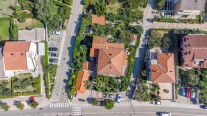 An aerial view of a residential area with houses featuring red-tiled roofs, a central road, and surrounding greenery. - Studio with 20sqm terrace near the city centre (Baška)