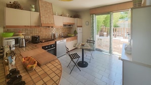 A kitchen with a dining area, a refrigerator, and a view of the outside. - Awesome home in Tourbes (Tourbes)