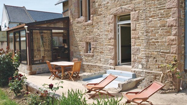 A stone building with a covered patio, outdoor seating, and a pool area. - Pet friendly home in Tredrez-Locquemeau (Tredrez-Locquemeau)