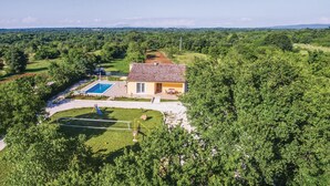 A house with a swimming pool, surrounded by lush greenery and a clear sky. - Gorgeous home in Butkovici (Butkovici)
