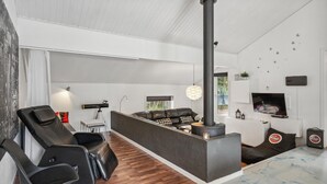 Una sala de estar moderna con chimenea, un sofá, una mesa de centro y un televisor montado en la pared.